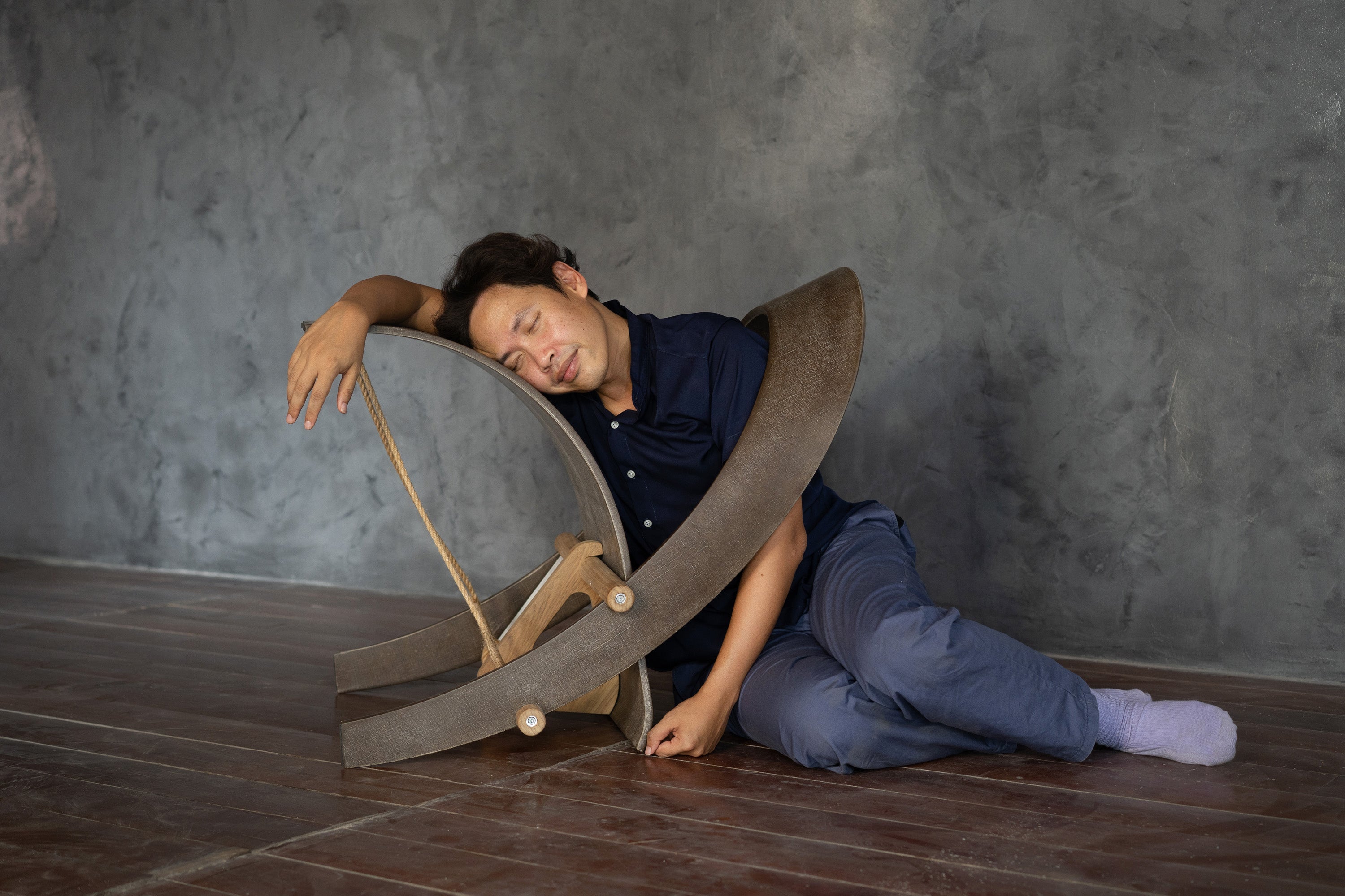 Person lying on the floor resting on Hemp Chair in an awkward position